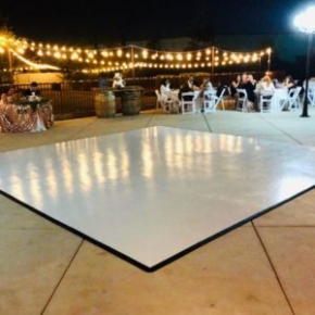 Slate White style dance floor is ready for dancing at this nighttime wedding reception.