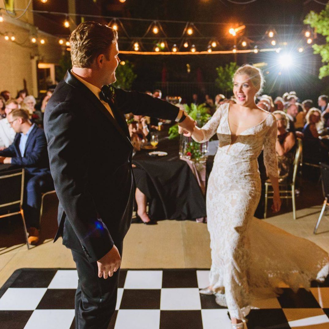 Couple dances on a classic checkered Black and White Slate style wedding dance floor