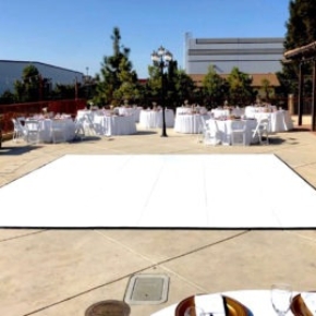 Slate white dance floor in the center of a wedding setup