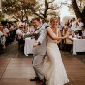 Happy bride and groom dancing on SnapLock Plus Dark Maple style dance floor