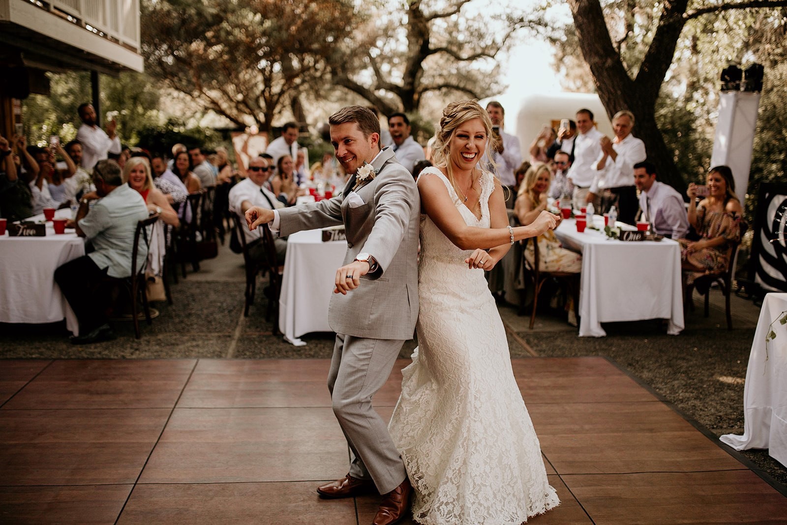 Happy bride and groom dancing on SnapLock Plus Dark Maple style dance floor