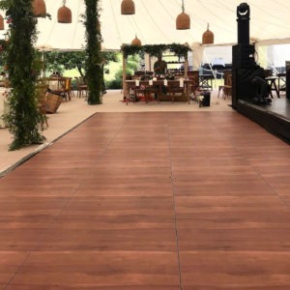 Dark Maple Plus dance floor in front of a stage at a tent event