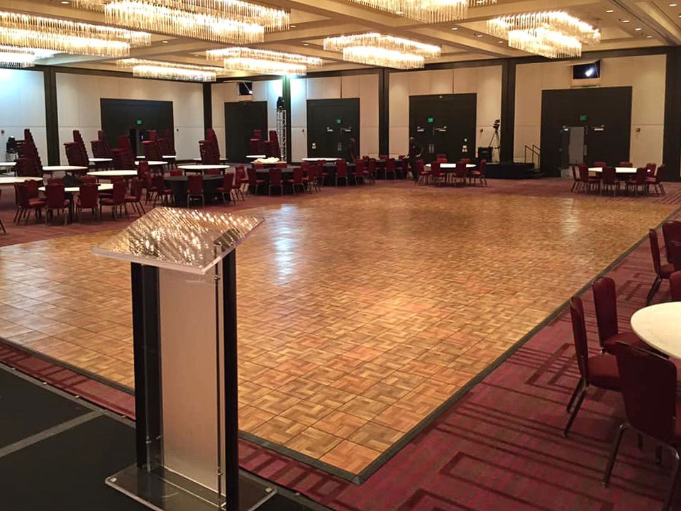A large oak style dance floor with edging in an event space