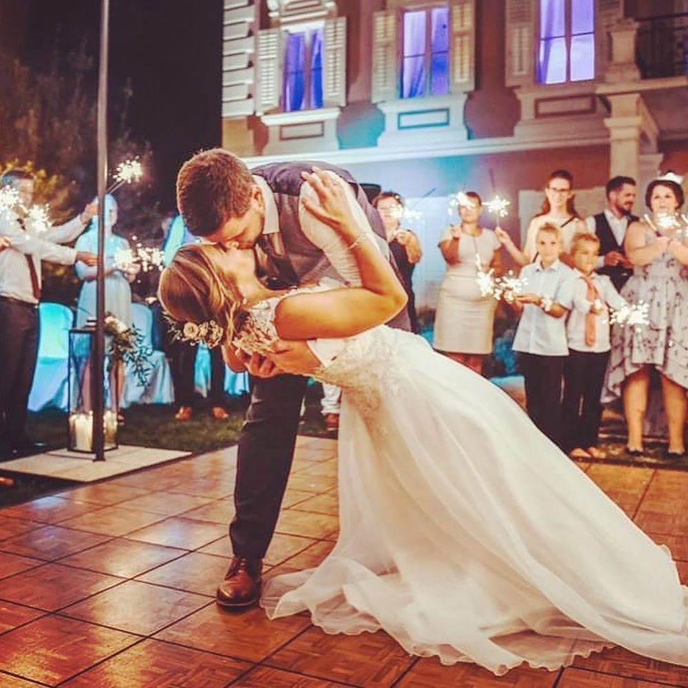 Newlywed couple kisses on Teak style wedding dance floor