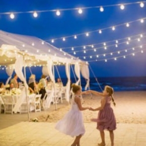 Girls dancing on a slate white dance floor at a beach wedding