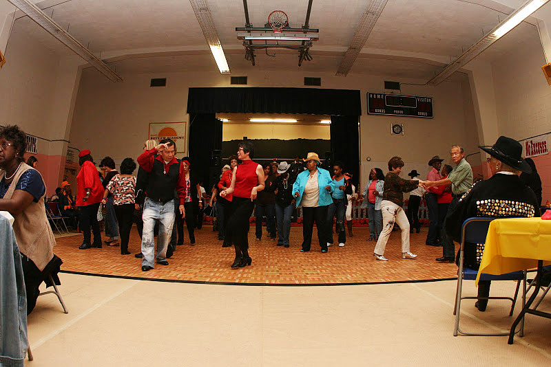 People dance on a large Oak style dance floor at a gymnasium