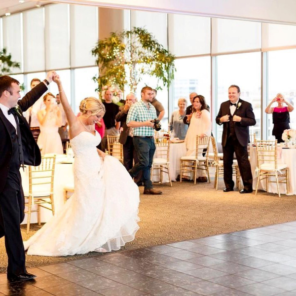 Couple celebrates at their wedding, walking out onto Luxury Black Marble style dance floor