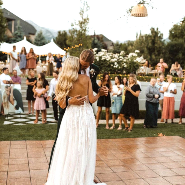 Bride and groom dance outdoors on a Teak style dance floor