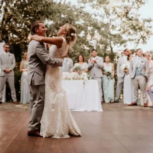 Couple dances on dark maple dance flooring.
